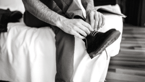 An image of a man putting on a boot.